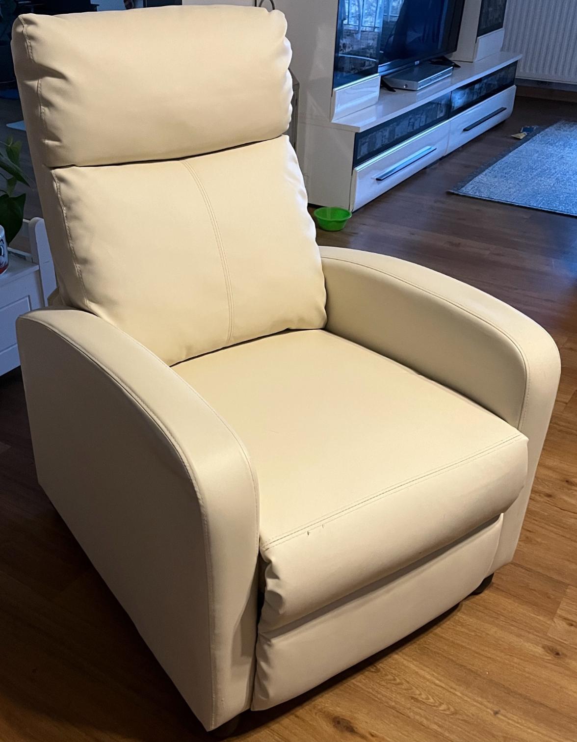 Ein beigefarbener, gepolsterter Relaxsessel mit hoher Rückenlehne und geschwungenen Armlehnen.