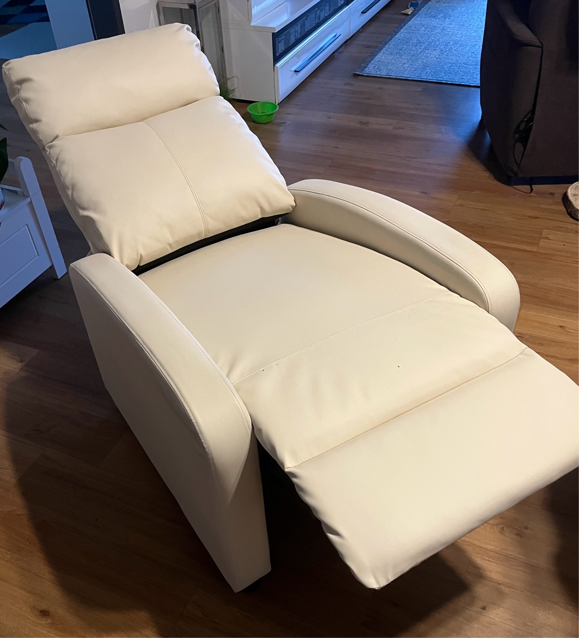 Ein beiger Relaxsessel mit verstellbarer Rückenlehne und Fußteil,