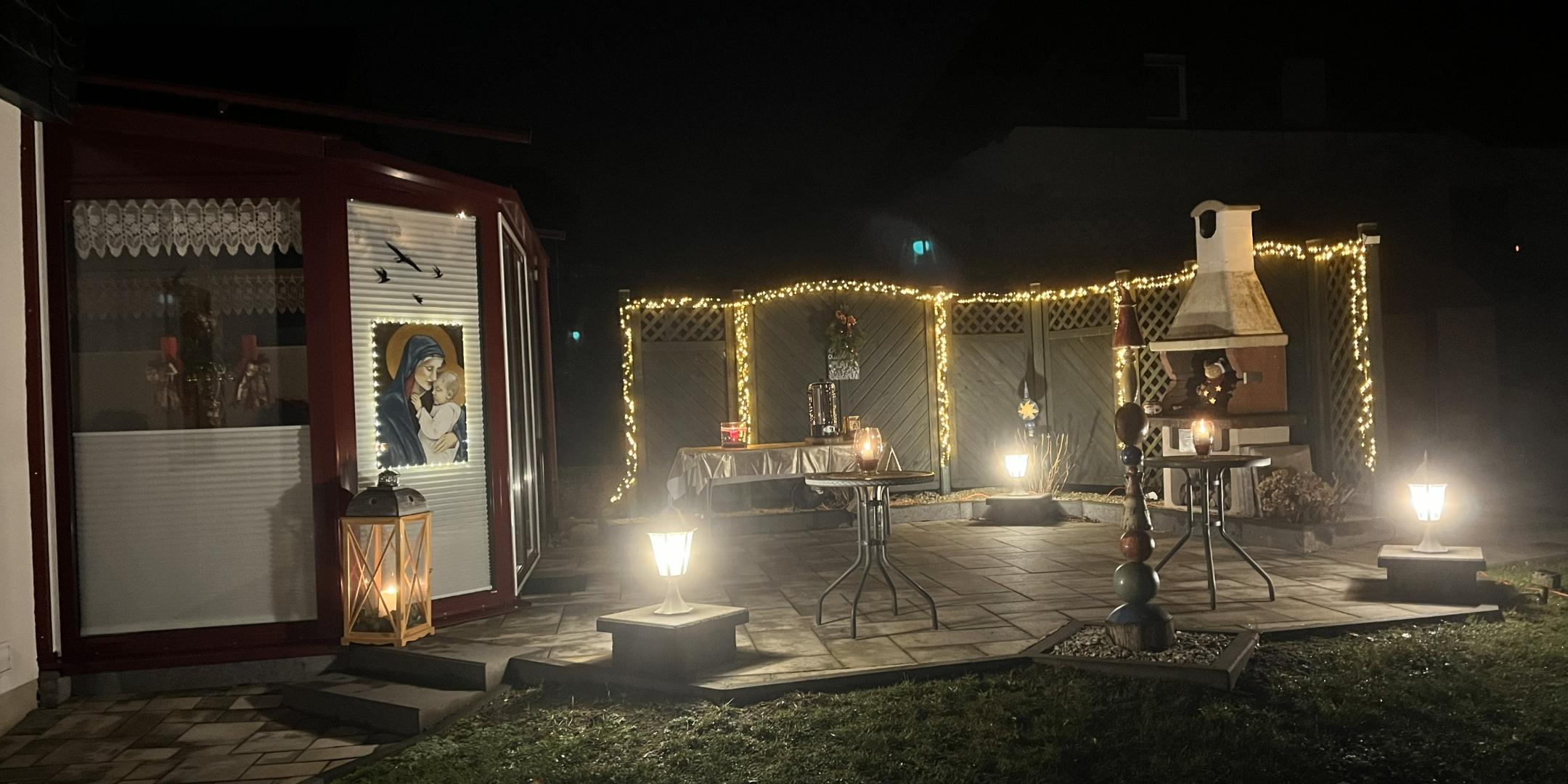 Die beleuchtete Terrasse mit Lichtern, Kerzen und dem Marienbild, Tischen und Kamin im Freien. (c) Margit Sperber Die beleuchtete Terrasse mit Lichtern, Kerzen und dem Marienbild, Tischen und Kamin im Freien.