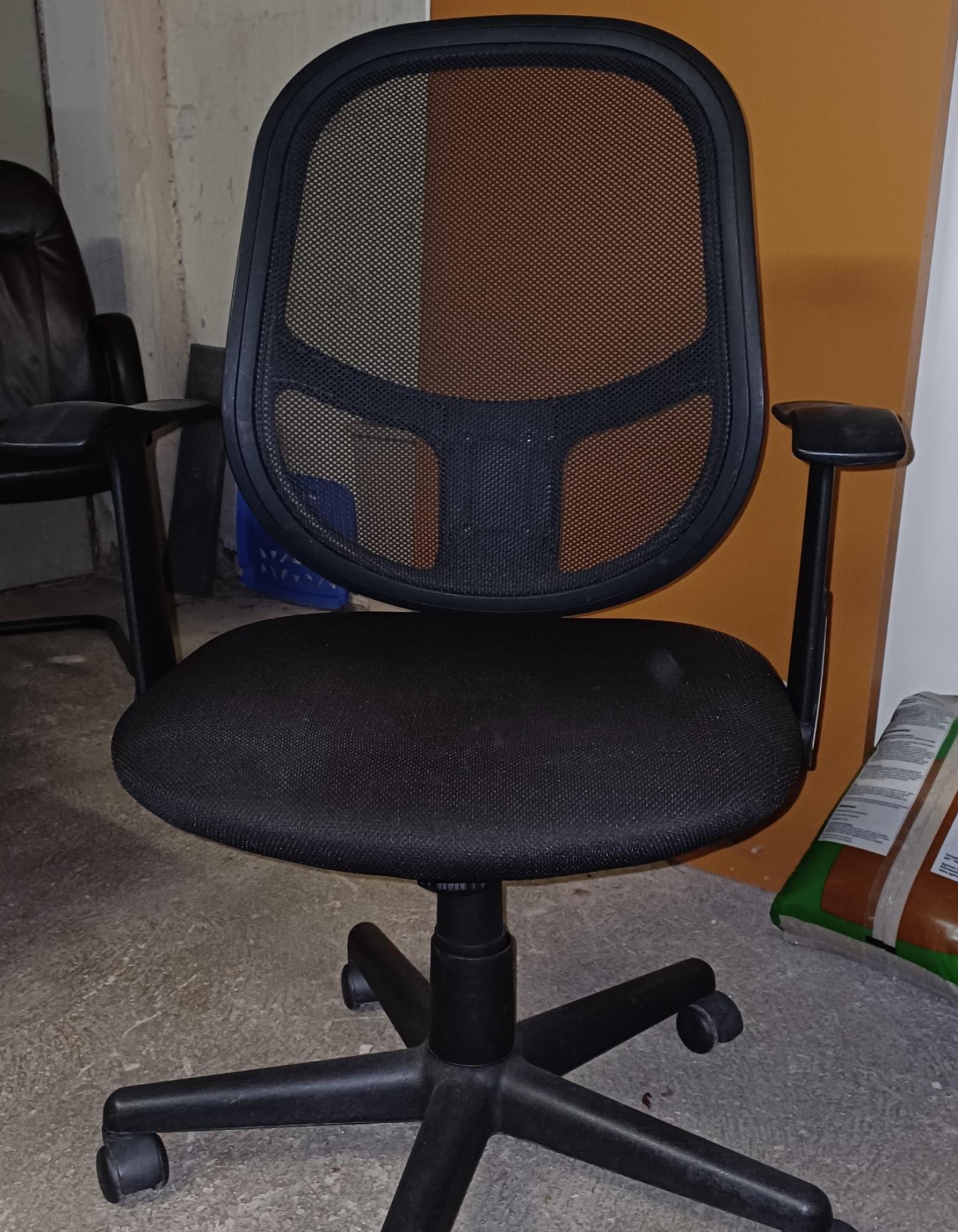 Der Stuhl ist ein schwarzer Bürostuhl mit Netzrücken, gepolsterter Sitzfläche, Kunststoffarmlehnen und einer fünfarmigen Basis mit Rollen.