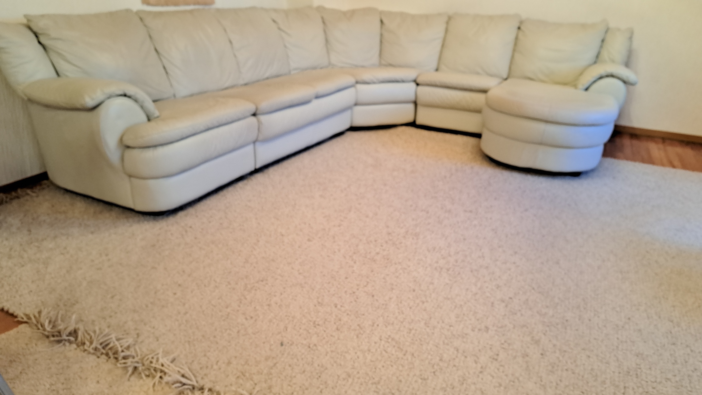 Ein großes, helles Ecksofa mit weichen Polstern und abgerundeten Formen.