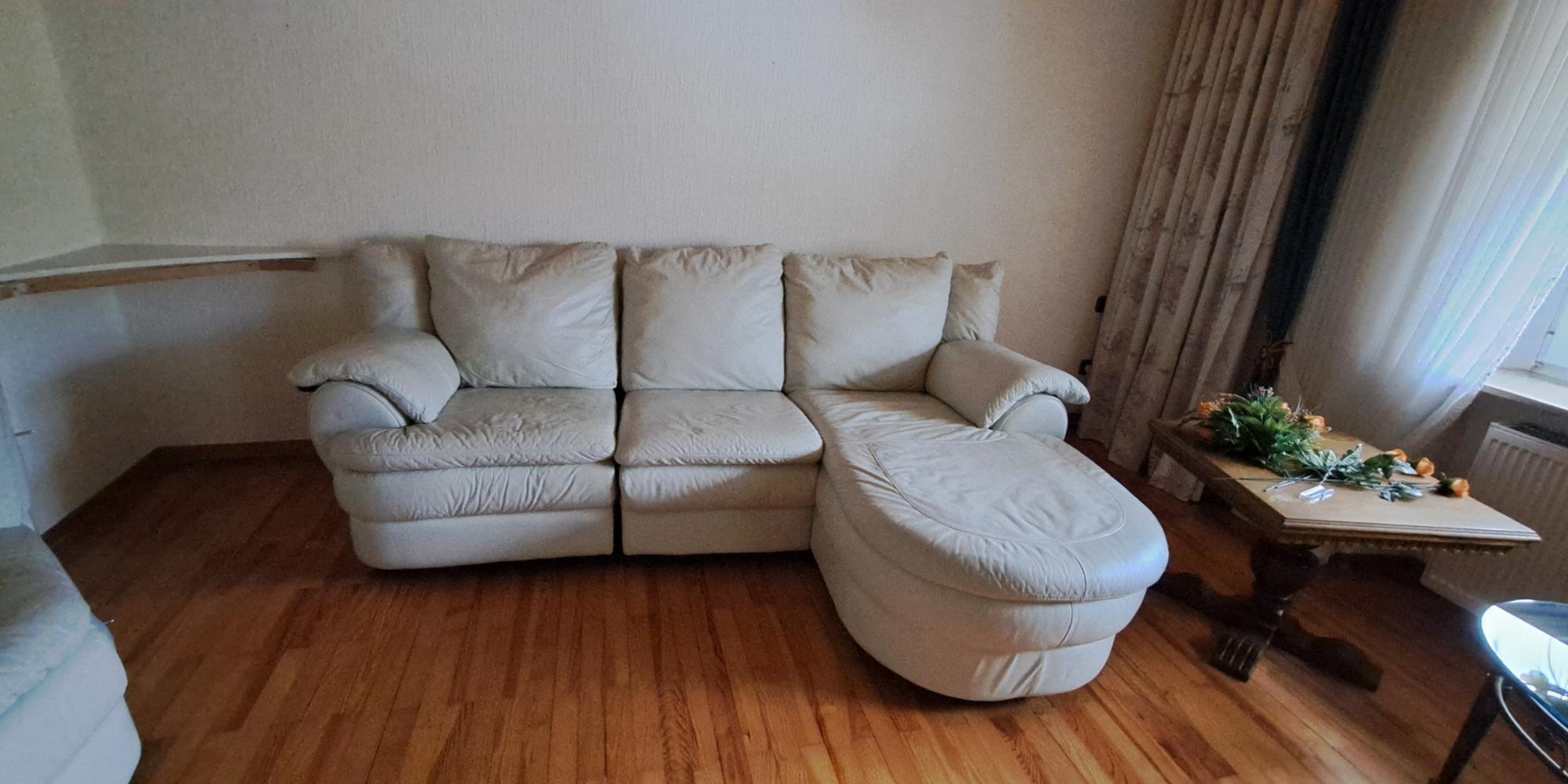 Ein großes, helles Ecksofa mit weichen Polstern und abgerundeten Formen.