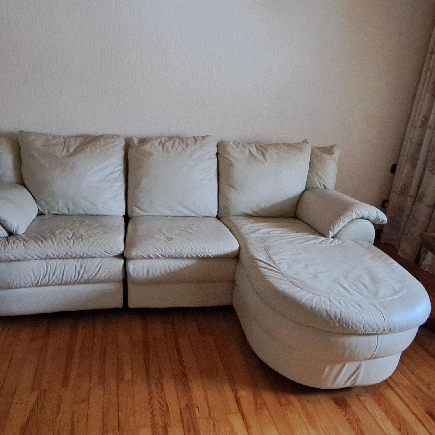 Ein großes, helles Ecksofa mit weichen Polstern und abgerundeten Formen.