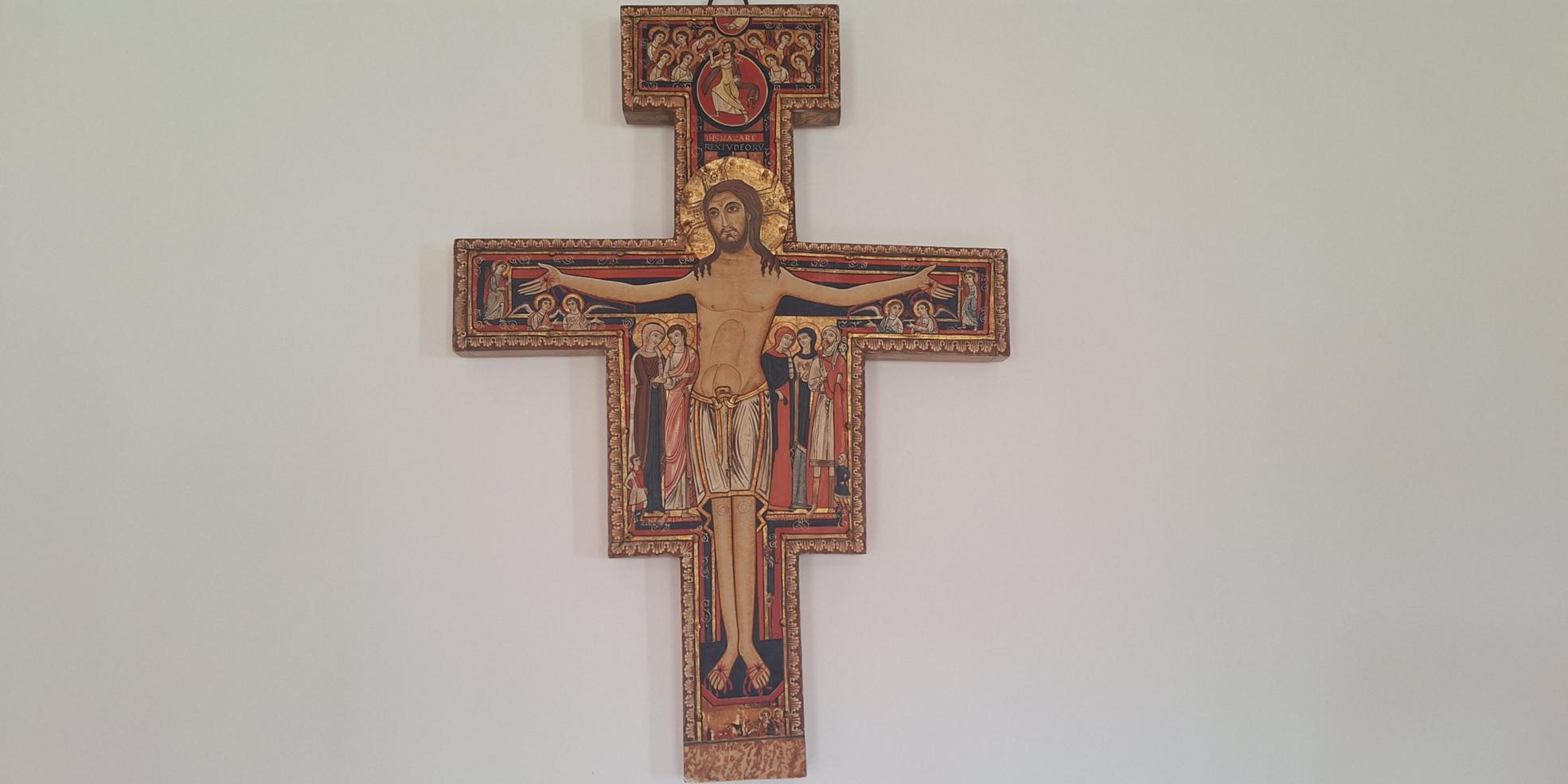 Kreuz von San Damiano mit der Darstellung des gekreuzigten Christus, reich verziert mit religiösen Figuren und goldfarbenen Ornamenten