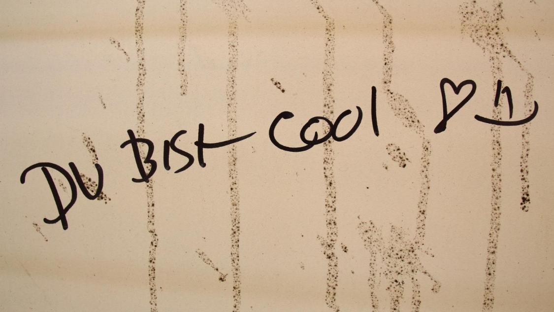 Handschriftlicher Schriftzug „Du bist cool“ mit Herzsymbol auf heller Oberfläche.