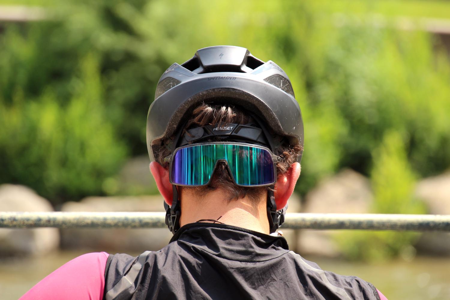 Radfahrer von hinten mit Helm und reflektierender Sportbrille.