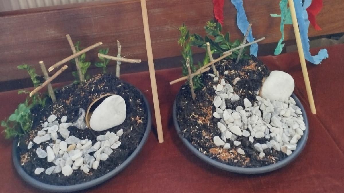 Zwei kleine Oster‑ bzw. Grabgärten mit Palmzweigen, bunt geschmückt mit farbigen Bändern.