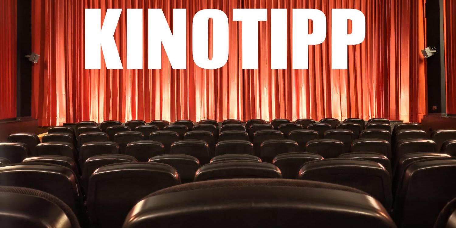 Leerer Kinosaal mit roten Vorhängen und großem „KINOTIPP“-Schriftzug.