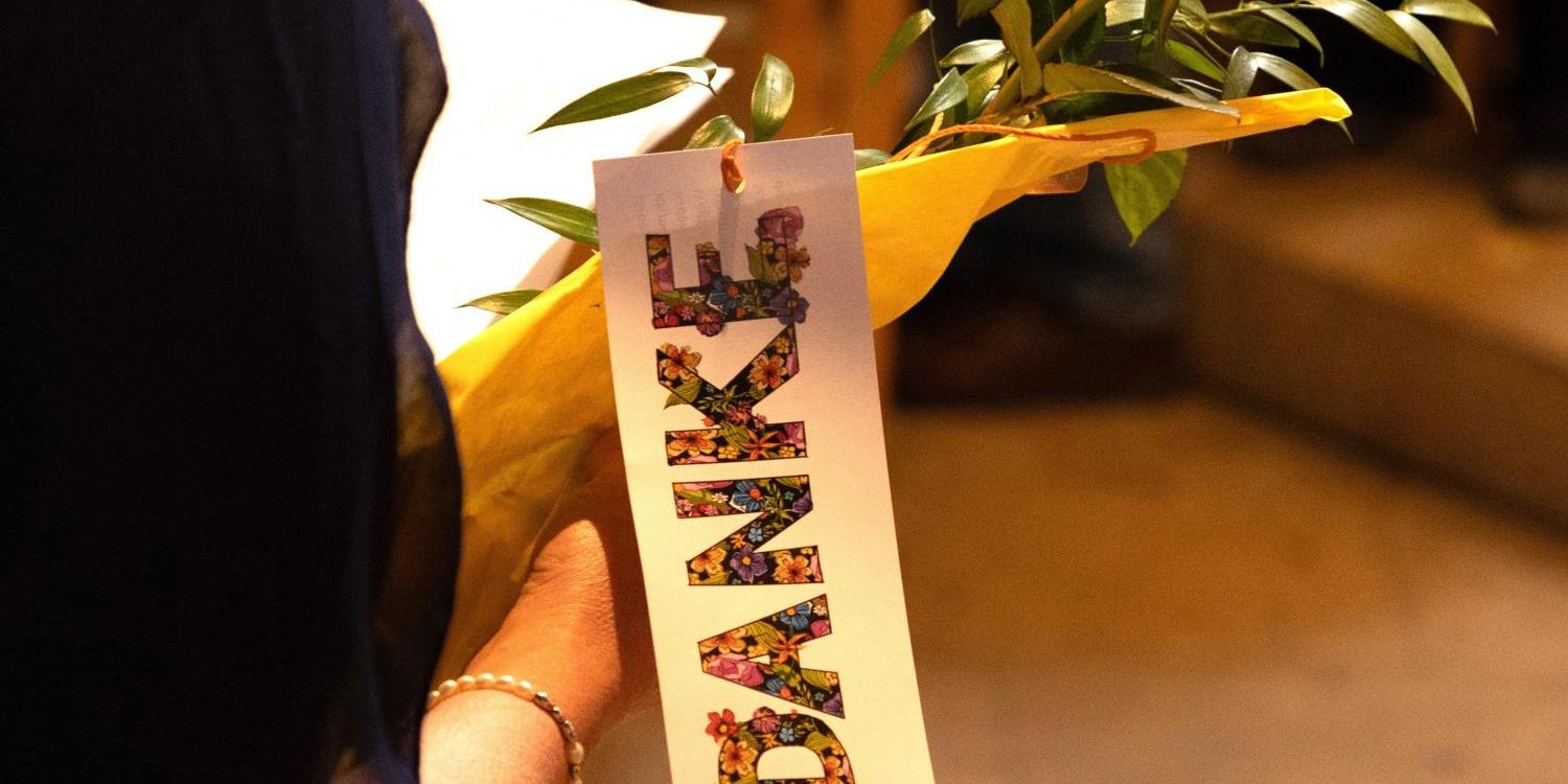 Eine Person hält eine orangefarbene Rose, eingewickelt in gelbes Papier. Daran hängt ein Schild mit dem Wort „DANKE“ in bunten Blumenbuchstaben, der Hintergrund ist unscharf. (c) Dunja Puschmann/Pfarrbriefservice.de Eine Person hält eine orangefarbene Rose, eingewickelt in gelbes Papier. Daran hängt ein Schild mit dem Wort „DANKE“ in bunten Blumenbuchstaben, der Hintergrund ist unscharf.