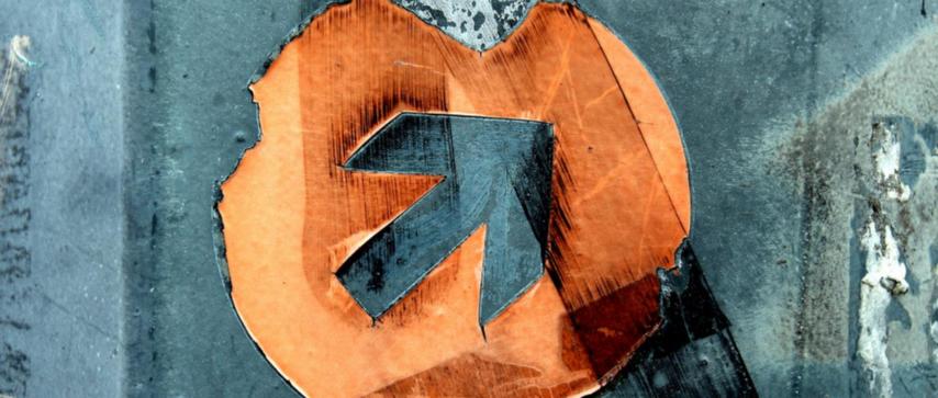 Ein blauer Pfeil, eingefasst von einem orangefarbenen Kreis.