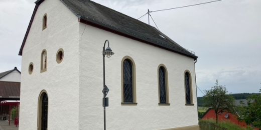 Eine kleine, weiß verputzte Dorfkirche mit schmalen Rundbogenfenstern und steilem Schieferdach. (c) privat Eine kleine, weiß verputzte Dorfkirche mit schmalen Rundbogenfenstern und steilem Schieferdach.