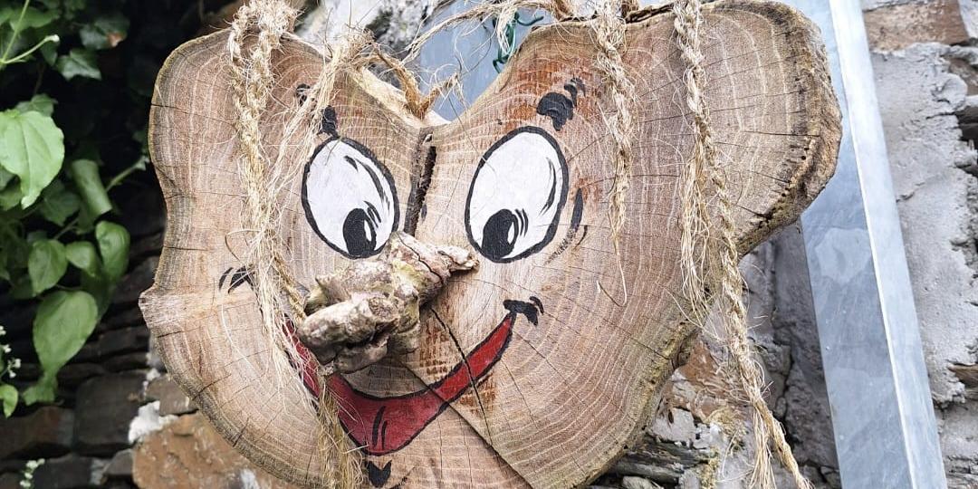 Aus einer Holzscheibe wurde mit Naturmaterialien ein lustiges Gesicht gebastelt