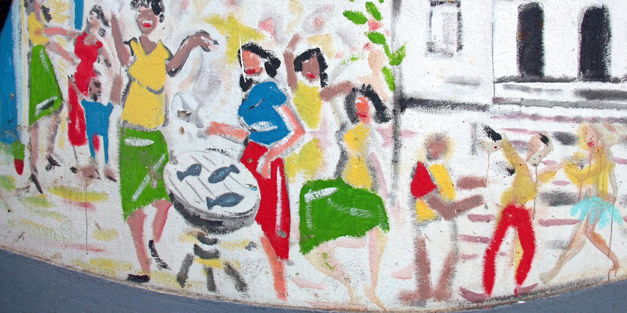 Frauen in bunter Kleidung feiern ausgelassen ein Fest und grillen