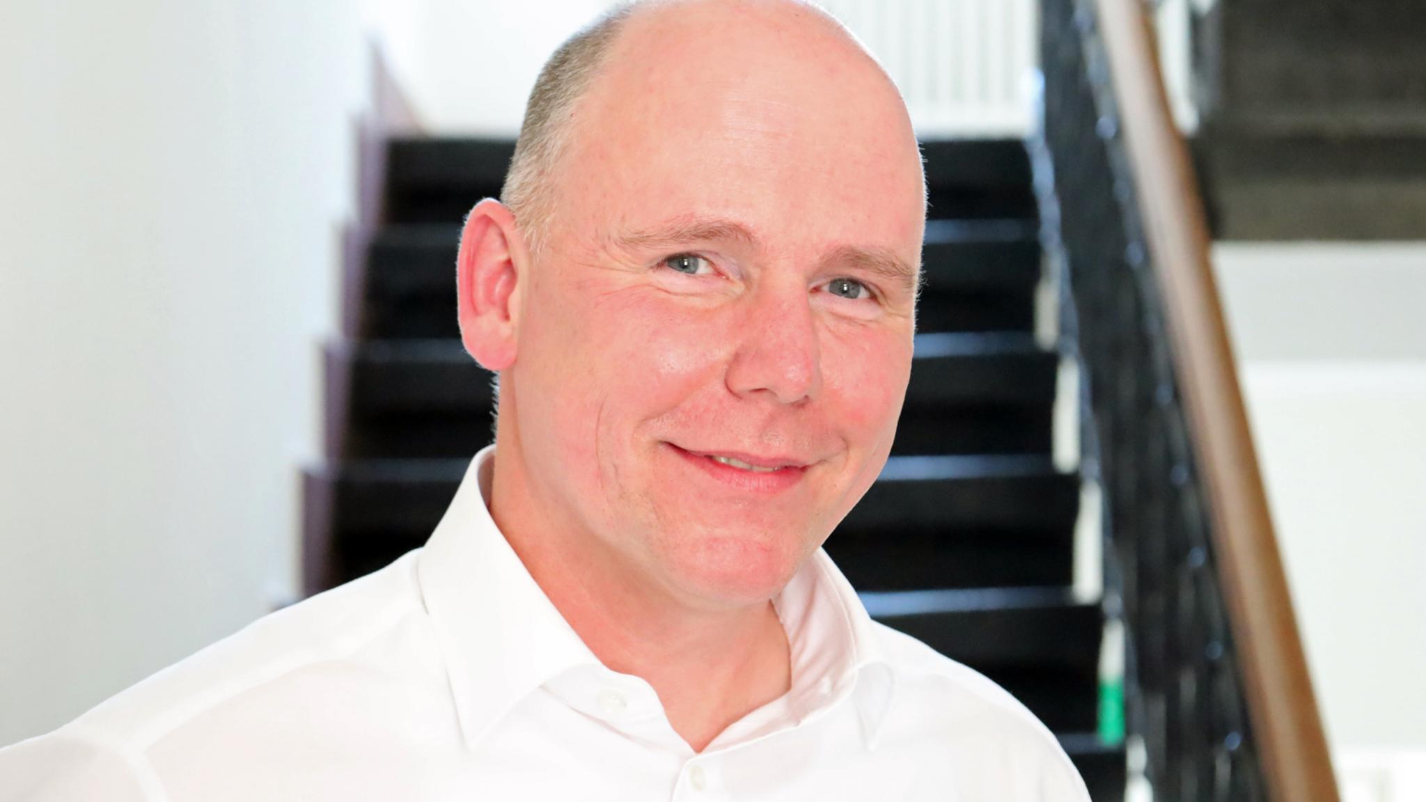 Auf dem Foto zu sehen ist Torsten Wahl vor einer Treppe stehend